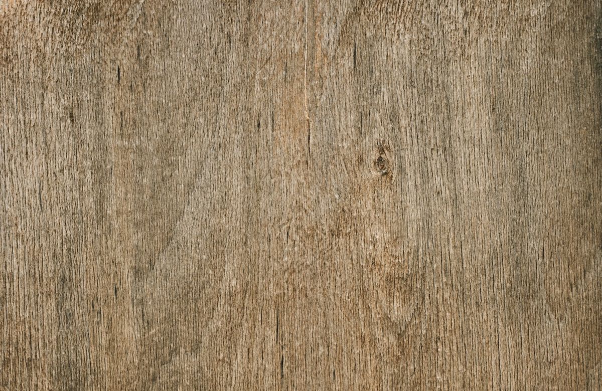 Nahaufnahme einer verwitterten Holzmaserung mit sichtbaren Astlöchern